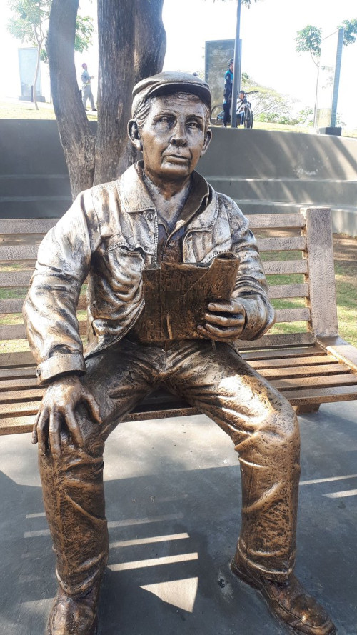 Statue of Horacio Hidrovo Peñaherrera sitting on a bench.